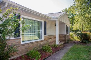 Exterior view of newly built home with glass window and greenery