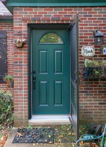 Green entry door on a brick home.