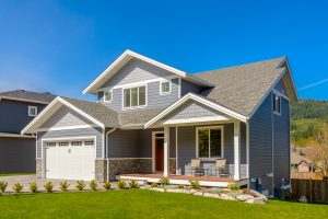 A blue house with an asphalt shingle roof