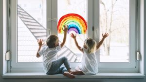 Happy children in front of window painting 
