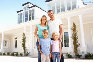 Family standing outside of white home 