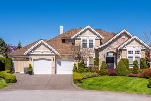 Beautiful exterior of newly built luxury home. Yard with green grass and walkway lead to front entrance.