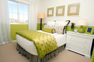 A bedroom with green walls and a wide picture window
