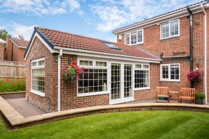 Modern sunroom extending into the garden surrounded by a block paved patio